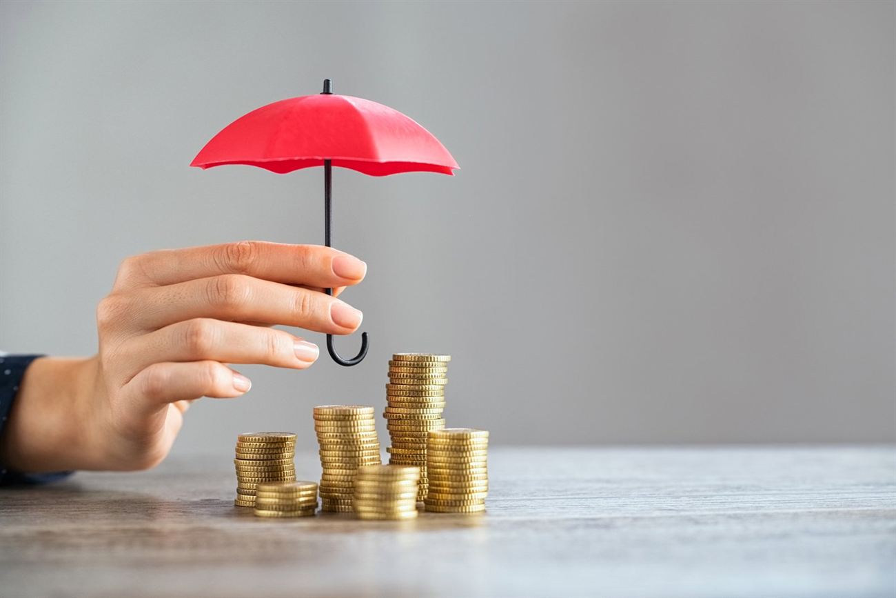 Coins and a small umbrella representing deposit protection